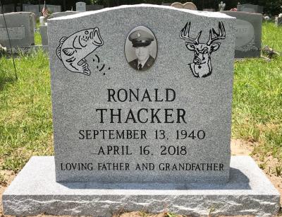 gray granite single upright headstone with bass and deer emblems